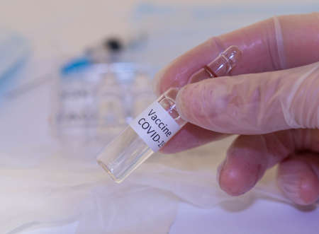 Medical doctor or laborant holding tube with nCoV Coronavirus vaccine for 2019-nCoV COVID virus.の写真素材