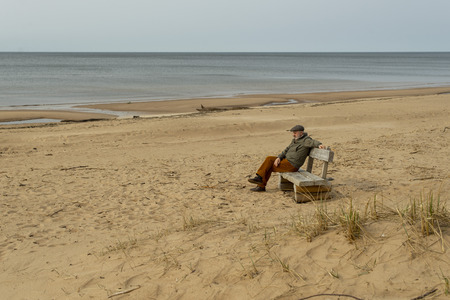 He sits on the sand, he sits on the sandの写真素材