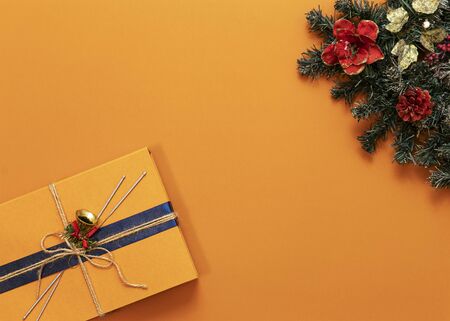 bright orange background, green tree in the upper right corner, orange gift box in the lower left corner, top view, horizontal frame, copy space in the centerの写真素材