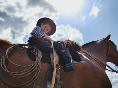 Young boy riding a horse at the local rodeo in California.の写真素材