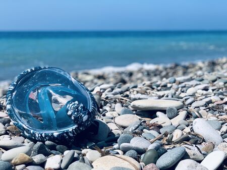 Snorkel gear by the sea. swimming mask scuby on the pebble beachの写真素材