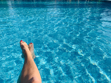 Woman's feet and the swimming pool