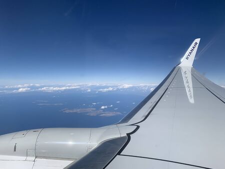 05.10.19 Greece Mykonos island Ryanair Looking through window aircraft during flight in wing with a nice blue skyのeditorial素材