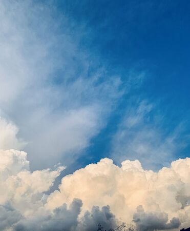 cumulus clouds against deep blue sky before sunsetの写真素材