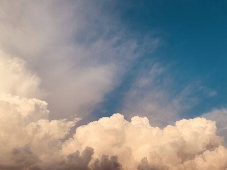 cumulus clouds against deep blue sky before sunsetの写真素材