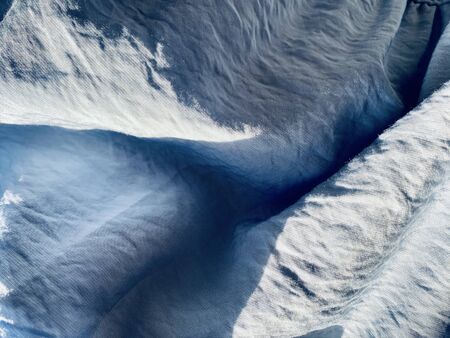blue grey fabric texture and background, Wavy fabric or crumpled textiles wallpaper. crumpled surface with sunlightの写真素材