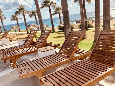 modern wooden sunbeds by turquoise swimming pool.の写真素材