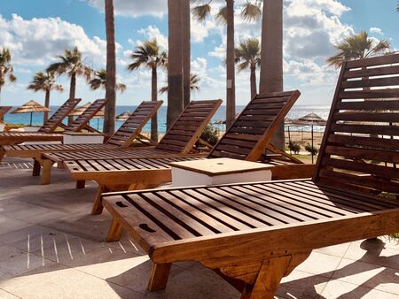 modern wooden sunbeds by turquoise swimming pool.の写真素材