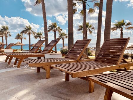 modern wooden sunbeds by turquoise swimming pool.の写真素材