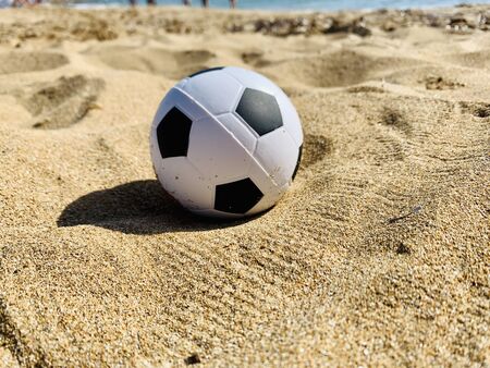 Football soccer ball on sandy beach backgroundの写真素材
