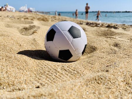 Football soccer ball on sandy beach backgroundの写真素材