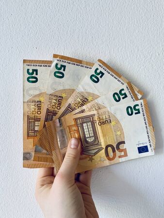 50 euros in female hand isolated on white background.の写真素材