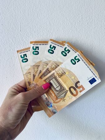 50 euros in female hand isolated on white background.の写真素材