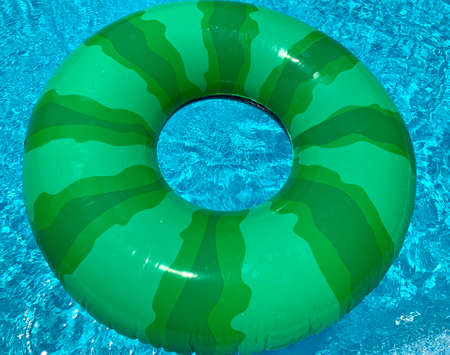 Inflatable ring floating in swimming pool on sunny dayの写真素材