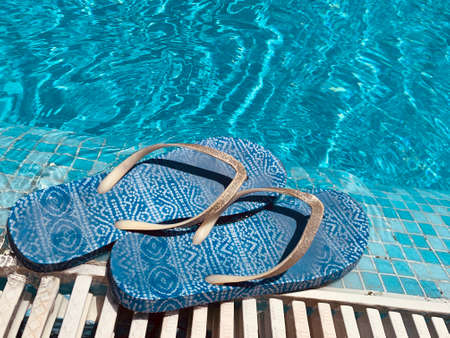 old summer Slippers near the swimming poolの写真素材