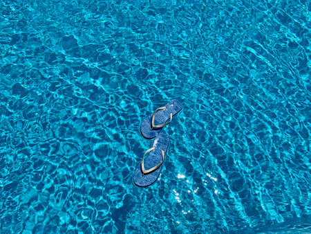 summer slipper with bright blue background and sun shadow. Summer vacation concept.の写真素材