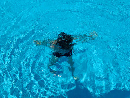 Boy swimming underwater in the swimming poolの写真素材