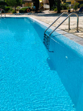 Close-up of ladder in swimming pool in resort, summer dayの写真素材