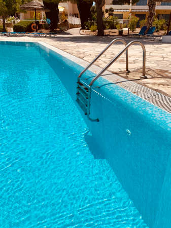 Close-up of ladder in swimming pool in resort, summer dayの写真素材