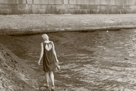 Young woman in beautiful dress walking near Neva river. Summerの写真素材