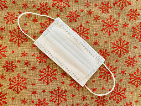 medical mask on red christmas background with snowflakes.の写真素材