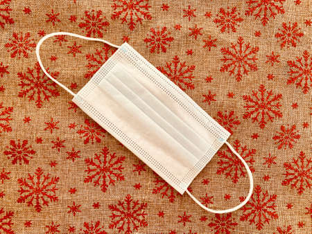 medical mask on red christmas background with snowflakes.の写真素材