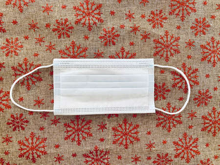 medical mask on red christmas background with snowflakes.の写真素材