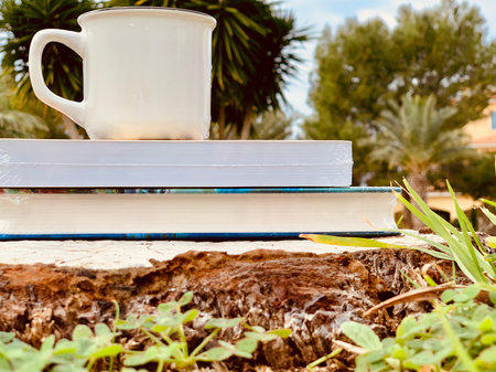 stack of books and a Cup of coffee on the green grass in autumnの写真素材