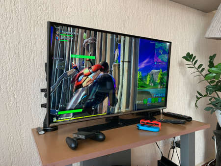 10.04.2021 Cyprus Paphos Tv set with Fortnite computer game on screen in the home during quarantine in self isolation. Screen showing the Game Computer screen with Fortnite game, production of Epic Games.のeditorial素材
