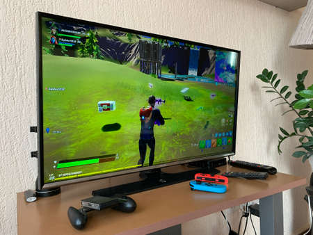 10.04.2021 Cyprus Paphos Tv set with Fortnite computer game on screen in the home during quarantine in self isolation. Screen showing the Game Computer screen with Fortnite game, production of Epic Games.のeditorial素材