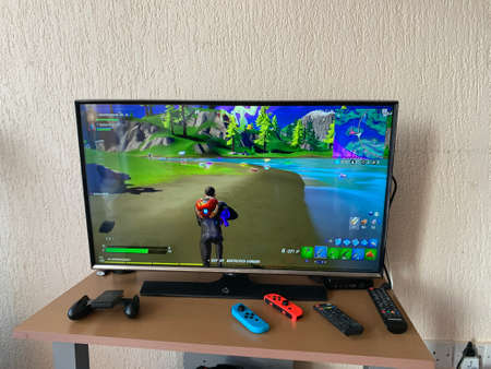 10.04.2021 Cyprus Paphos Tv set with Fortnite computer game on screen in the home during quarantine in self isolation. Screen showing the Game Computer screen with Fortnite game, production of Epic Games.のeditorial素材