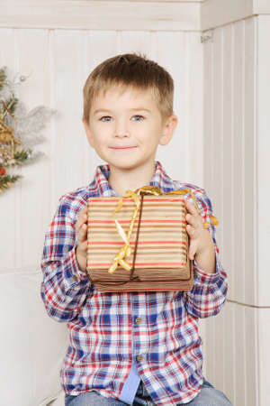 Cute boy holding christmas gift amazed with smile for surprise.の写真素材