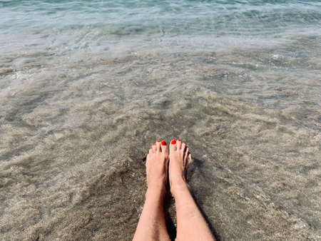 Vacation holidays. Woman feet closeup of girl relaxing on beach on sunbed enjoying sun on sunny summer day. copy spaceの写真素材
