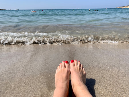 Vacation holidays. Woman feet closeup of girl relaxing on beach on sunbed enjoying sun on sunny summer day. copy spaceの写真素材