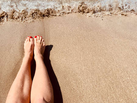 Vacation holidays. Woman feet closeup of girl relaxing on beach on sunbed enjoying sun on sunny summer day. copy spaceの写真素材
