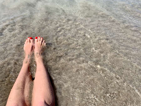 Vacation holidays. Woman feet closeup of girl relaxing on beach on sunbed enjoying sun on sunny summer day. copy spaceの写真素材