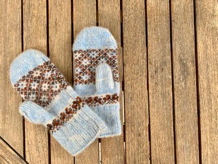 blue knitted mittens on wooden backgroundの写真素材
