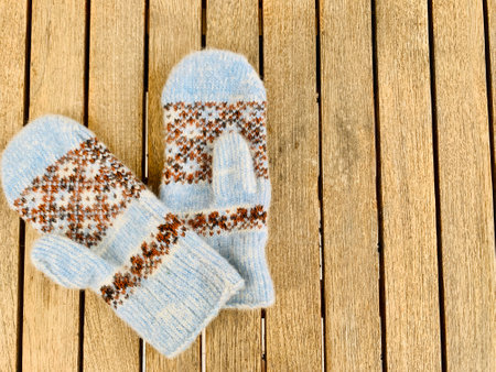 blue knitted mittens on wooden backgroundの写真素材