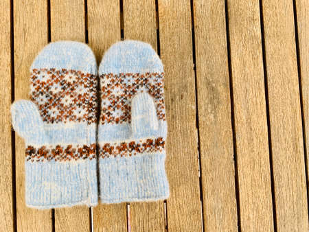 blue knitted mittens on wooden backgroundの写真素材