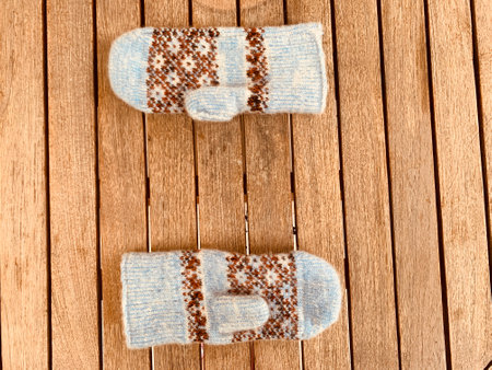blue knitted mittens on wooden backgroundの写真素材