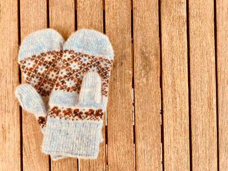 blue knitted mittens on wooden backgroundの写真素材