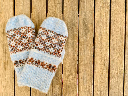 blue knitted mittens on wooden backgroundの写真素材