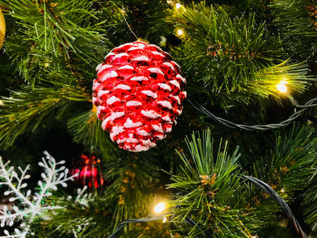 Vintage glass toy for decoration of Christmas tree. Dark red pine cone with snow.の写真素材
