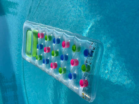colorful inflatable mattress floating on water surfaceの写真素材