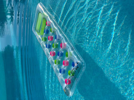 colorful inflatable mattress floating on water surfaceの写真素材