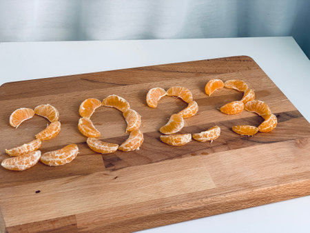 2023 year figures from slices of tangerine on wooden board top viewの写真素材