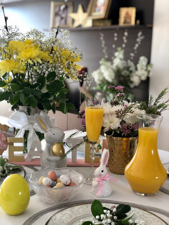 Easter table setting with flowers, eggs and bunny, selective focus