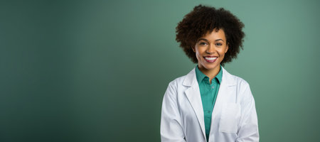 Modern Medical Education Concept. Portrait Of Smiling Black Female Doctor In White Coat Posing Over green Backgroundの素材