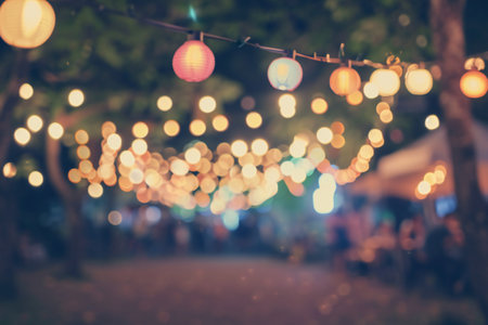 vintage tone blur image of night festival in garden with bokeh for background usage .の素材