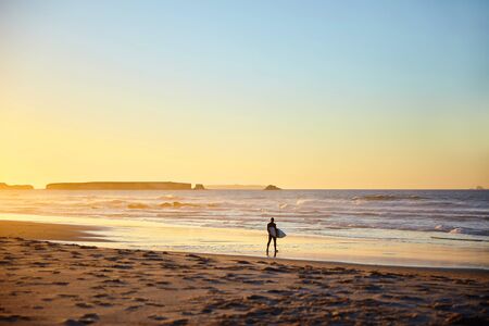 surfer walking along the coastの写真素材